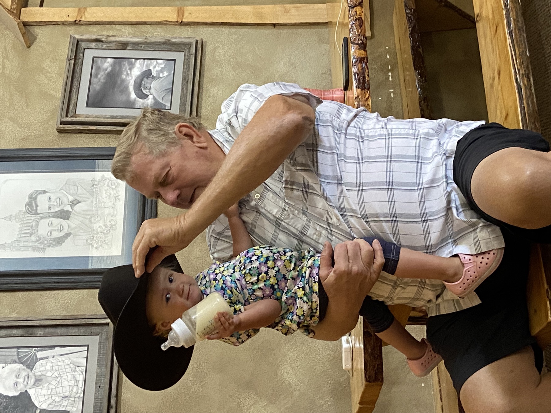 Ed holding a young child wearing a cowboy hat