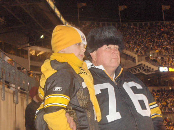 Ed holding a child at a football game