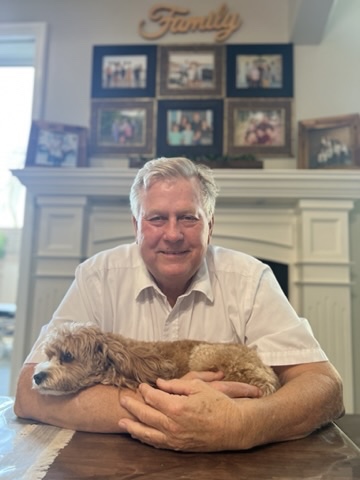 Ed holding a small dog at the family table